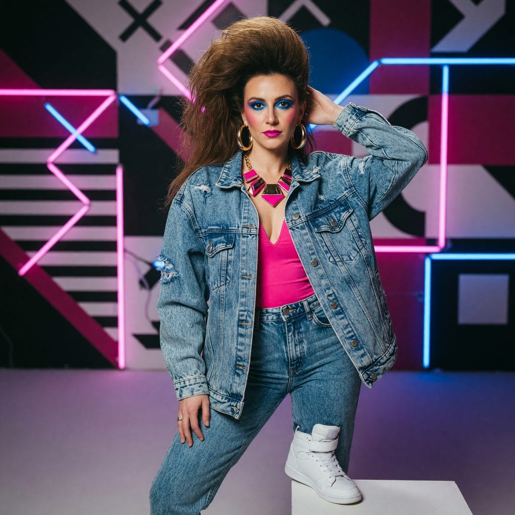 80s AI photo — neon studio set with geometric tubing, big hair and acid-wash jeans
